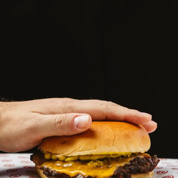 Un cliente dando un bocado a una burger en la calle